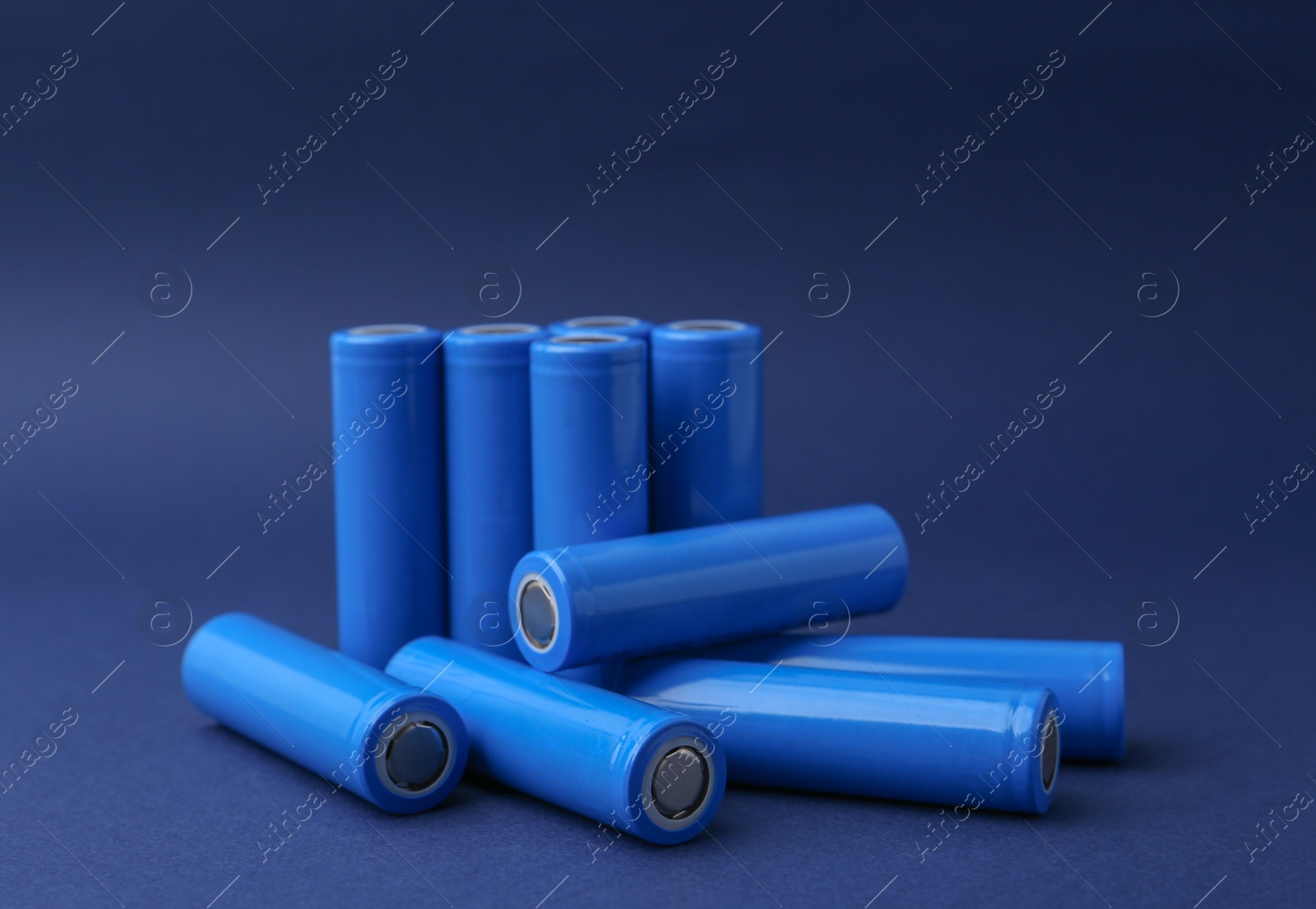 Photo of Many AA cell batteries on blue background, closeup