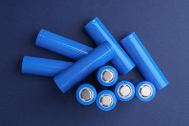 Photo of Many AA cell batteries on blue background, flat lay