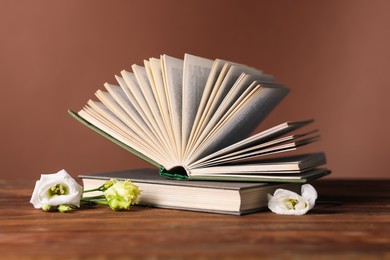 Books and beautiful flowers on wooden table, closeup