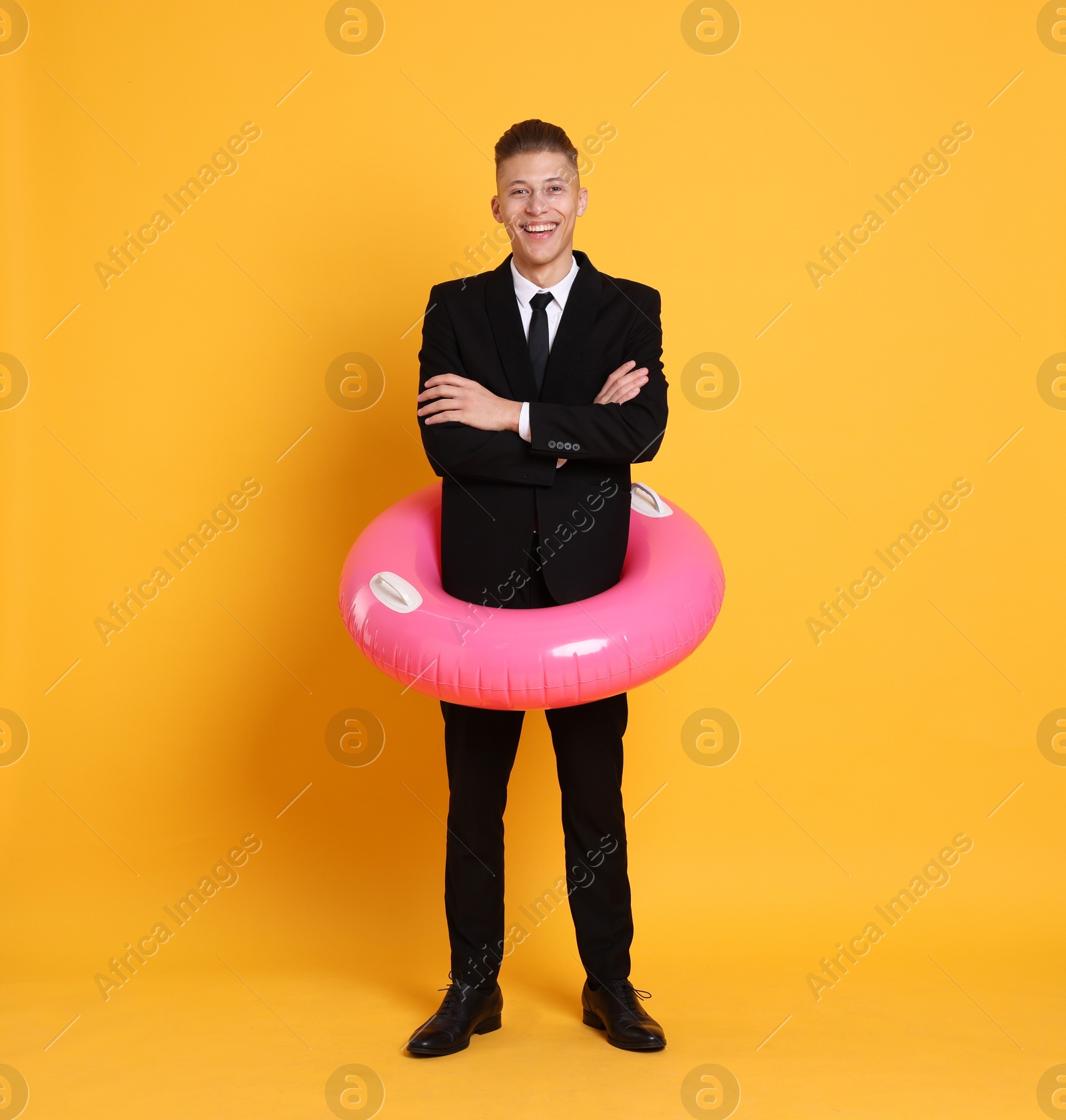 Photo of Businessman with inflatable ring on orange background