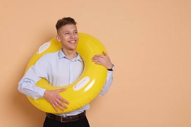 Photo of Businessman with inflatable ring on beige background, space for text