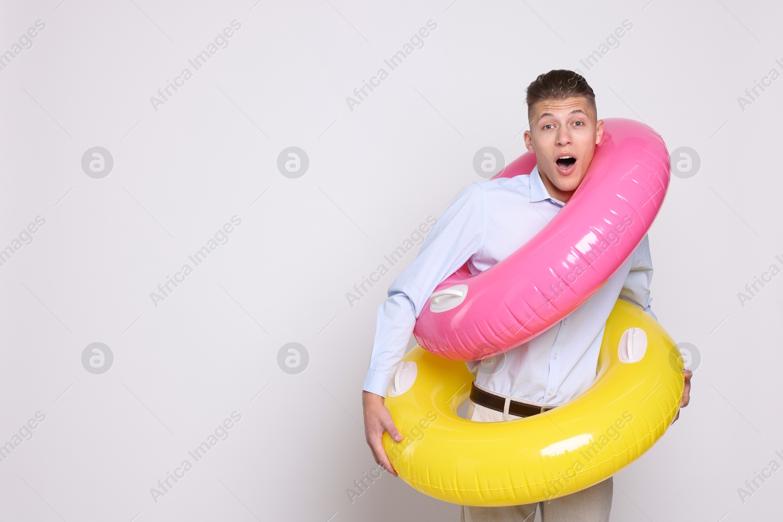 Photo of Businessman with inflatable rings on white background, space for text