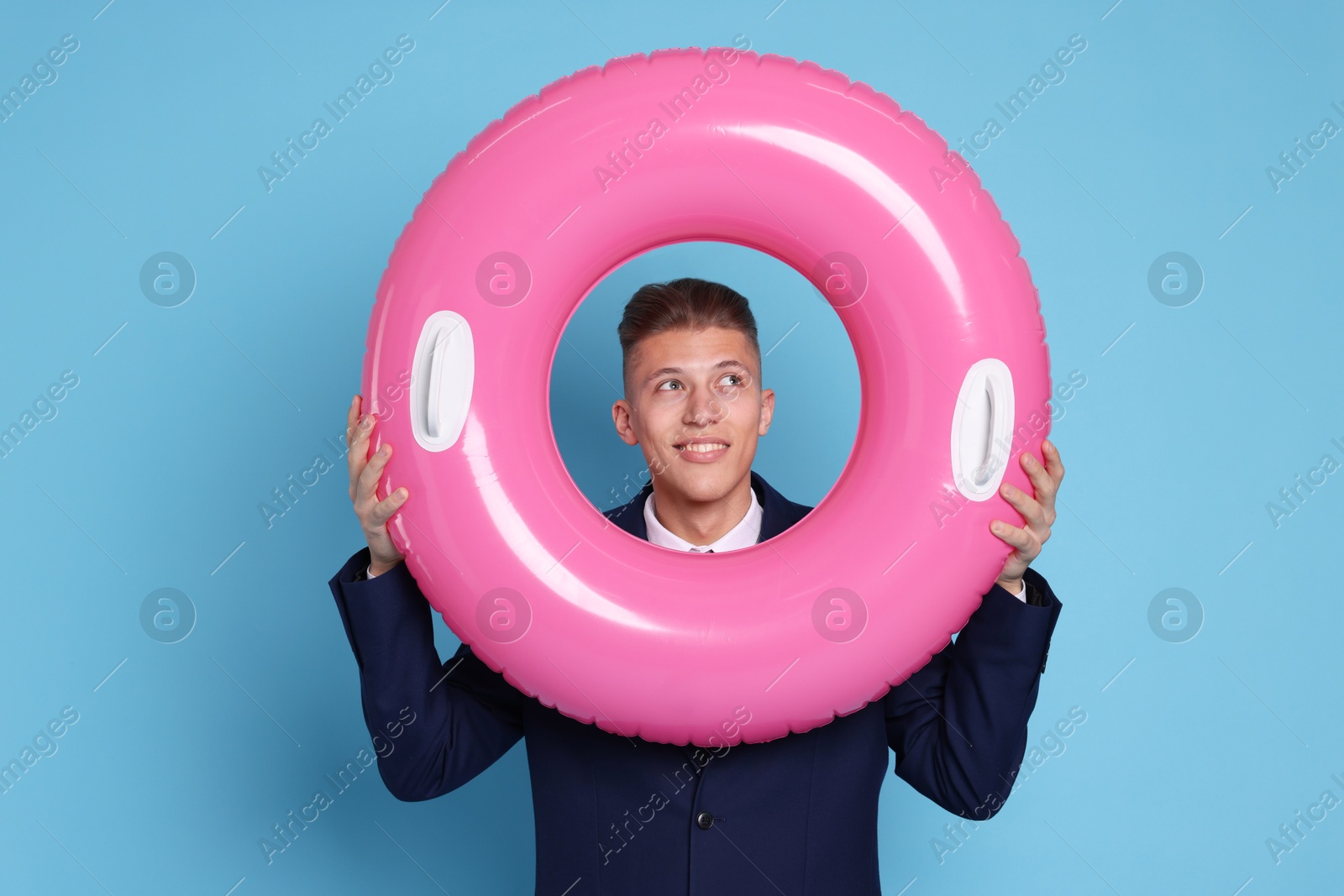 Photo of Businessman with inflatable ring on light blue background