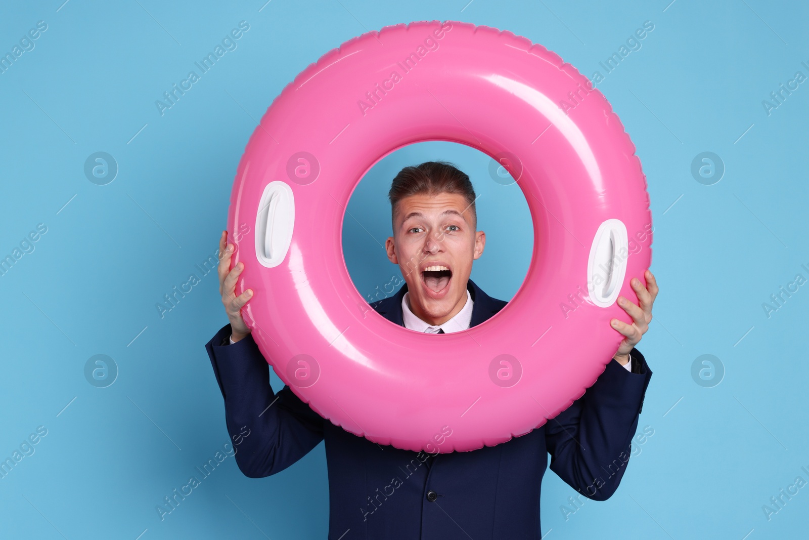 Photo of Businessman with inflatable ring on light blue background