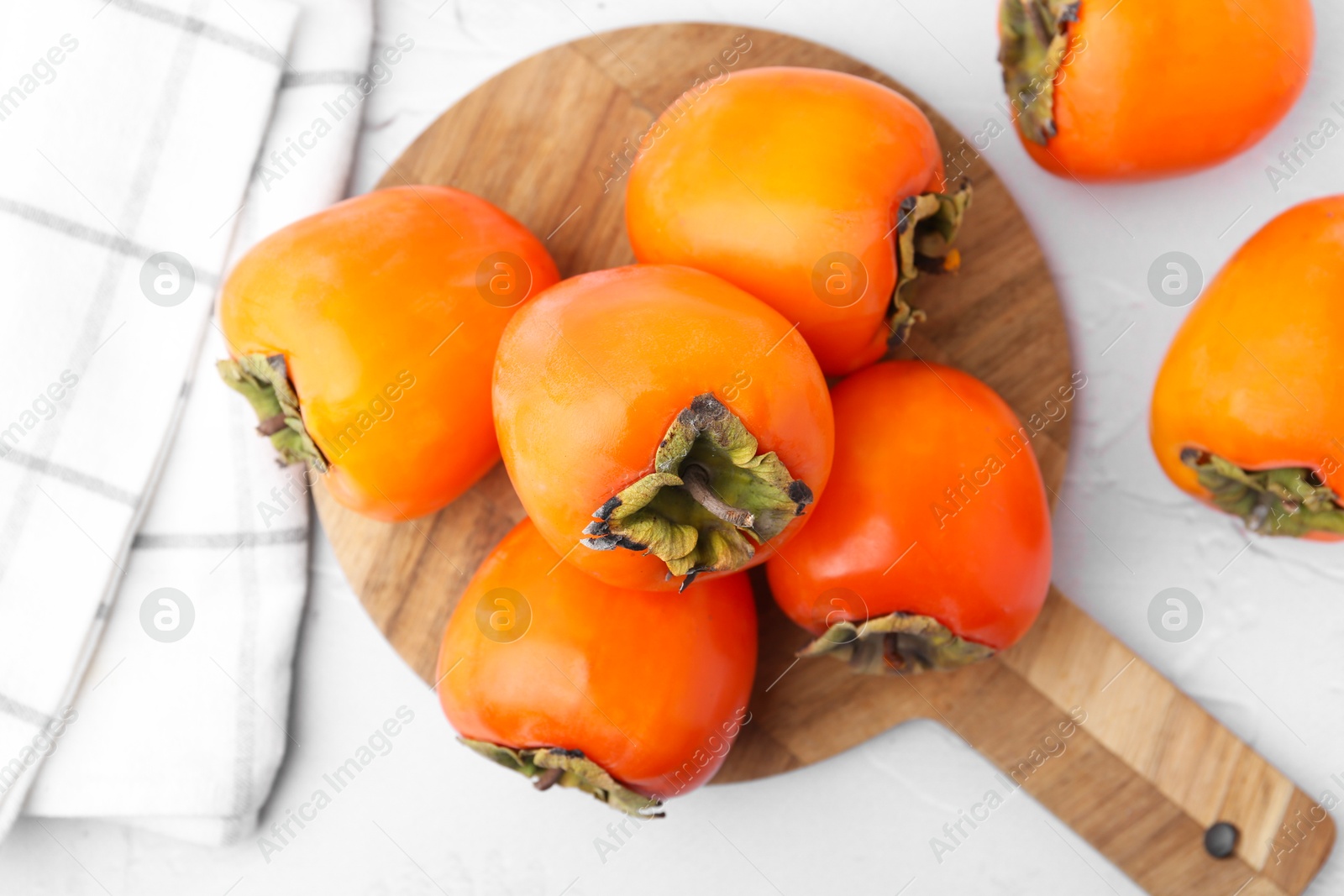 Delicious fresh juicy persimmons on white table, top view Photo of Delicious fresh juicy persimmons on white table, top view