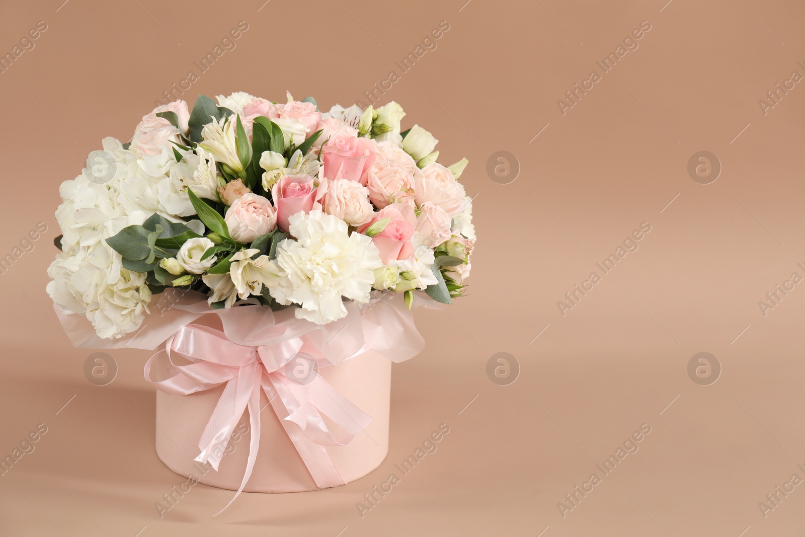 Photo of Bouquet of beautiful flowers on beige background, space for text