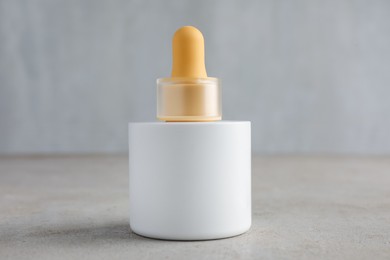 Photo of Bottle of skin care product on gray textured surface