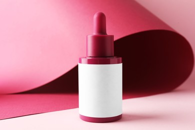 Bottle of skin care product on pink background