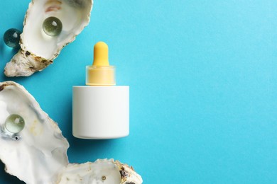 Photo of Bottle of skin care product, seashells and glass balls on light blue background, flat lay. Space for text