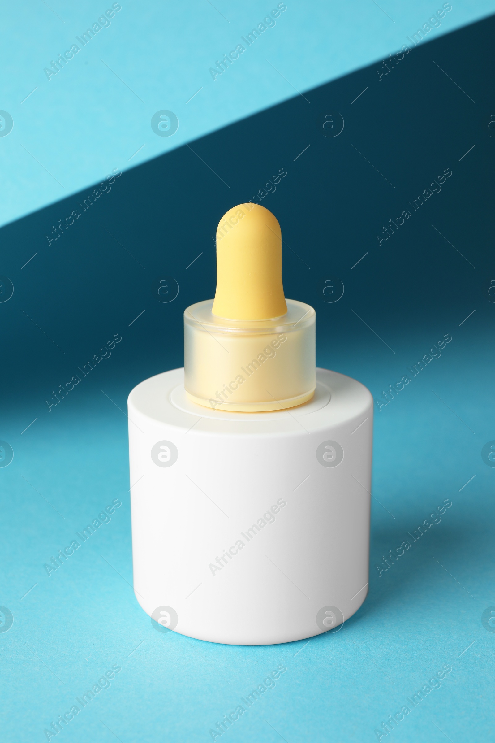 Photo of Bottle of skin care product on light blue background