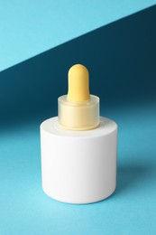 Photo of Bottle of skin care product on light blue background