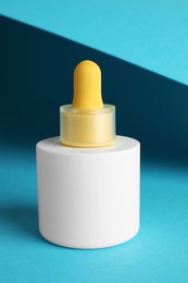 Photo of Bottle of skin care product on light blue background