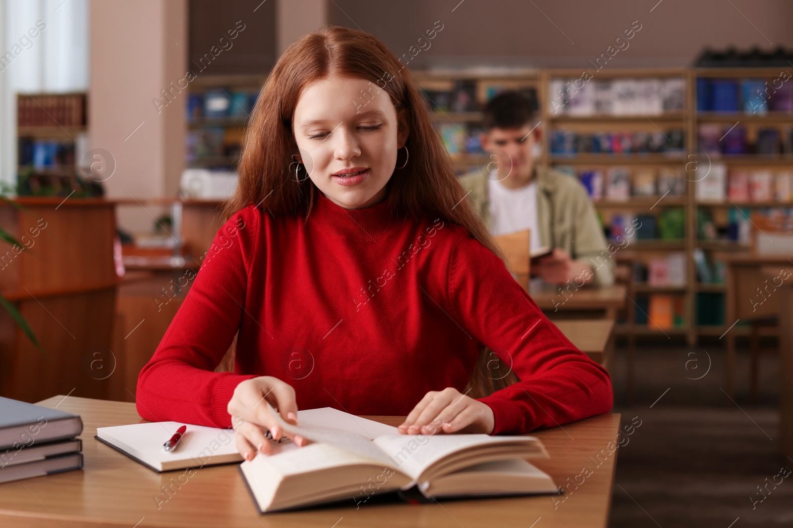 Photo of Girl studying at desk in public library