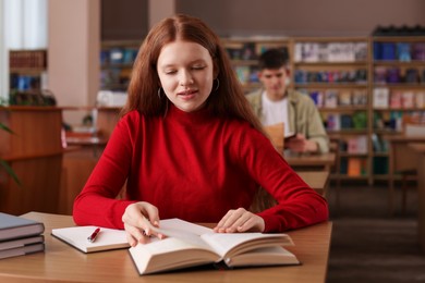 Photo of Girl studying at desk in public library