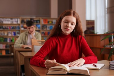 Photo of Girl studying at desk in public library