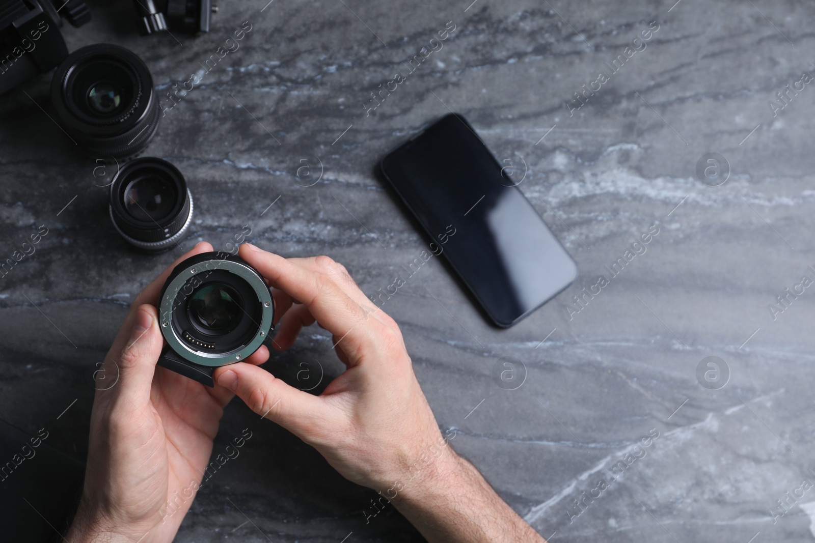 Photo of Photographer with camera lens at gray marble table, top view. Space for text