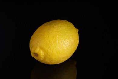 Photo of One fresh lemon on black background, closeup