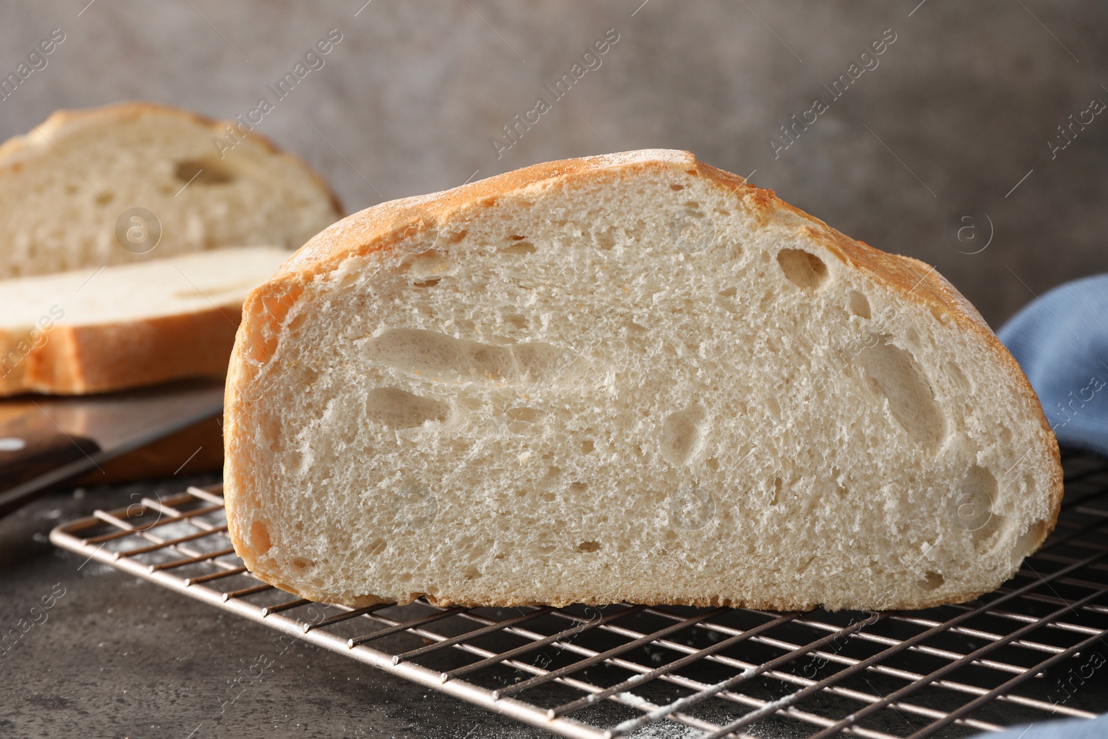 Photo of Cut fresh bread on grey table, closeup