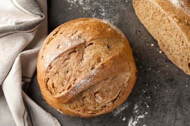 Photo of Whole and cut fresh bread on grey table, top view