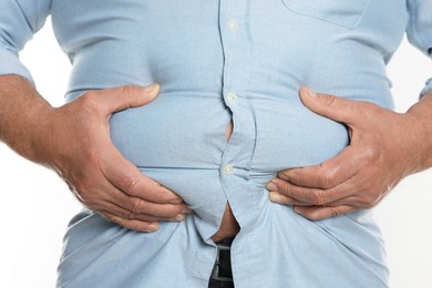 Photo of Overweight man in tight shirt on white background, closeup