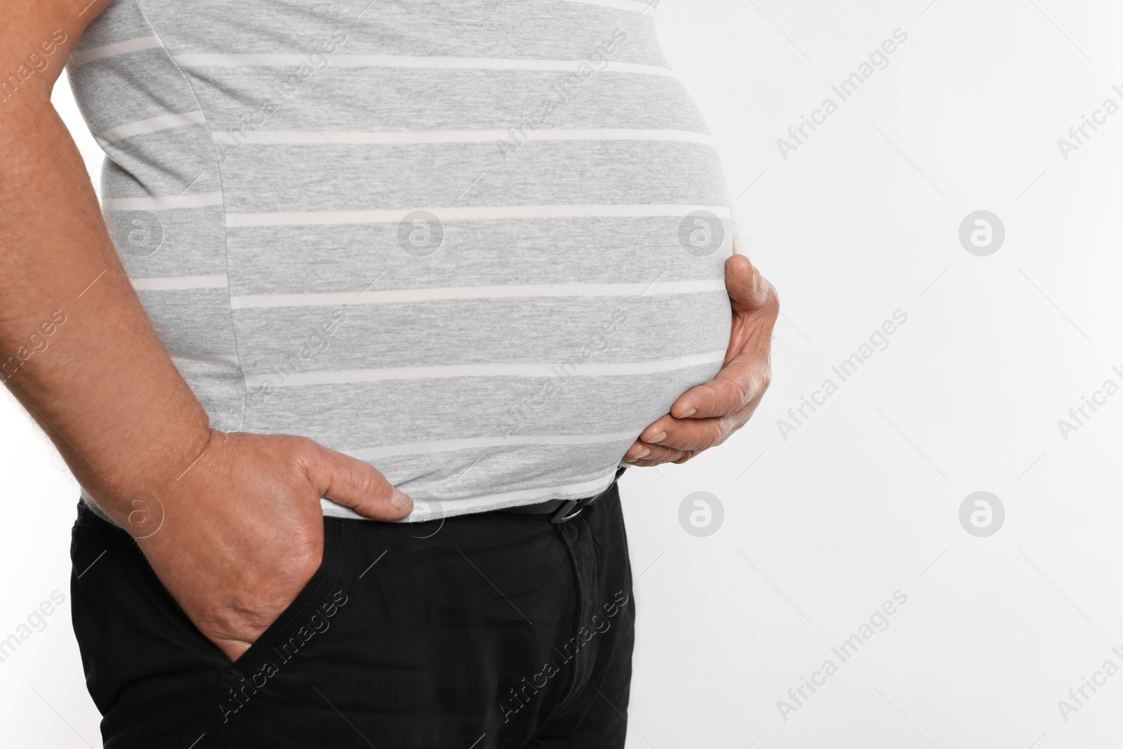 Photo of Overweight man in tight t-shirt on white background, closeup. Space for text