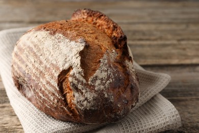 Photo of Freshly baked bread on wooden table, closeup. Space for text