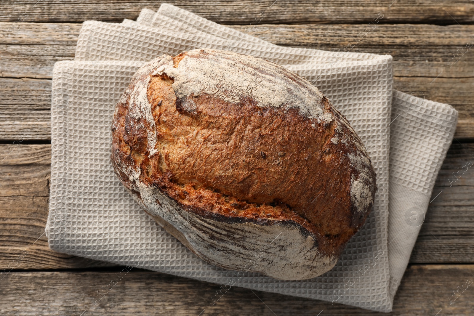 Photo of Freshly baked bread on wooden table, top view