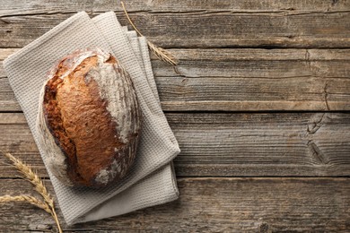 Photo of Freshly baked bread and spikes on wooden table, top view. Space for text