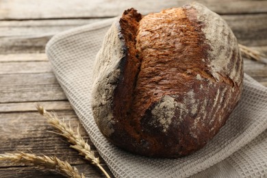 Photo of Freshly baked bread and spikes on wooden table, closeup