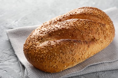 Photo of Freshly baked bread with seeds on grey table, closeup