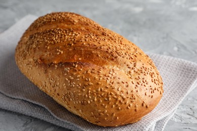 Photo of Freshly baked bread with seeds on grey table, closeup