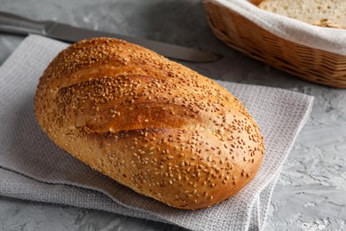 Photo of Freshly baked bread with seeds on grey table, closeup