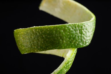 Photo of Fresh lime peel on black background, closeup