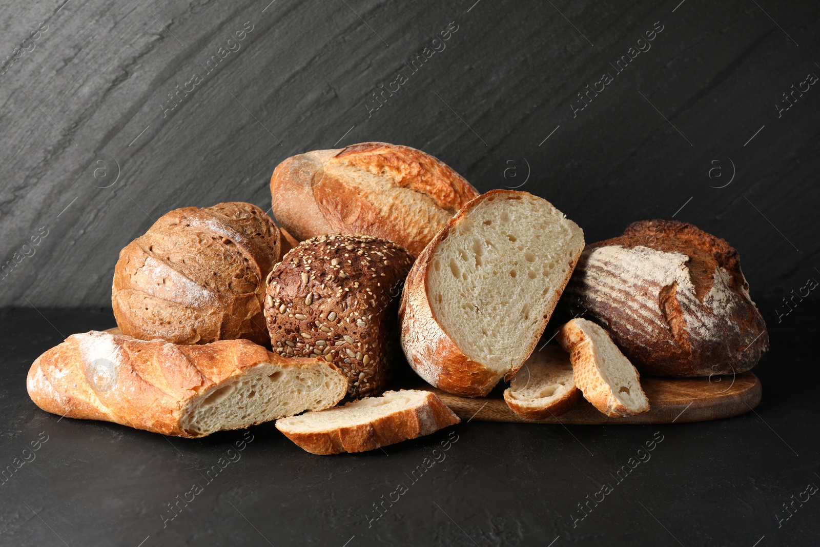 Photo of Whole and cut loafs of bread on black table