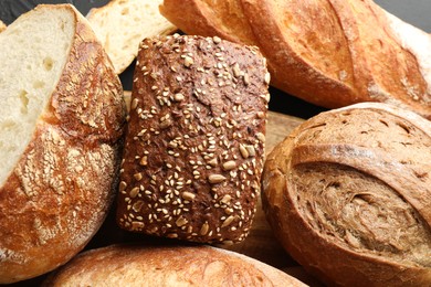 Photo of Whole and cut loafs of bread on table, closeup