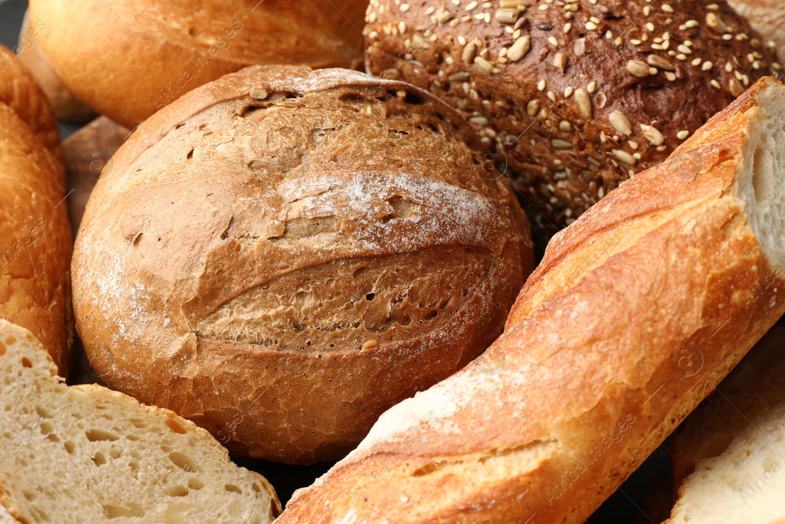 Photo of Whole and cut loafs of bread on table, closeup