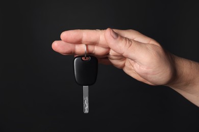 Photo of Man with car key on black background, closeup