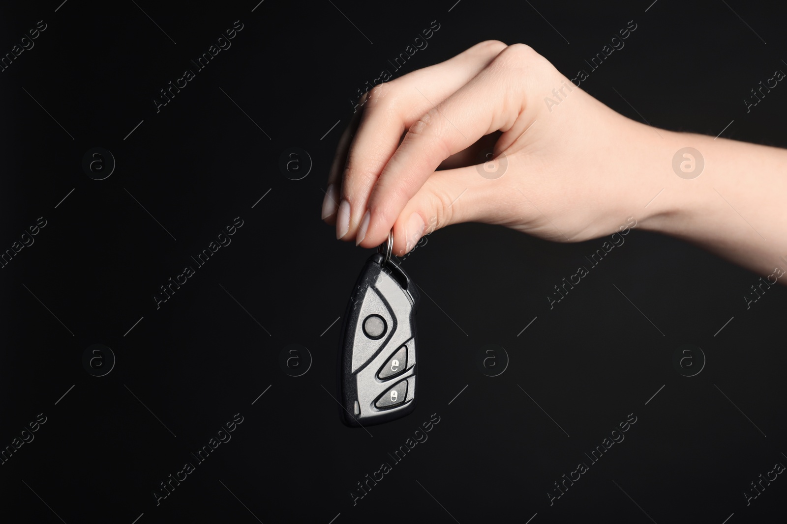 Woman with car flip key on black background, closeup. Space for text Photo of Woman with car flip key on black background, closeup. Space for text