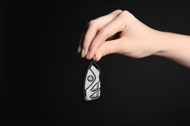 Photo of Woman with car flip key on black background, closeup. Space for text