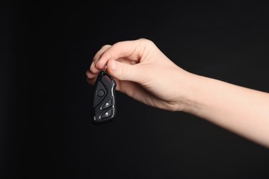 Photo of Woman with car flip key on black background, closeup