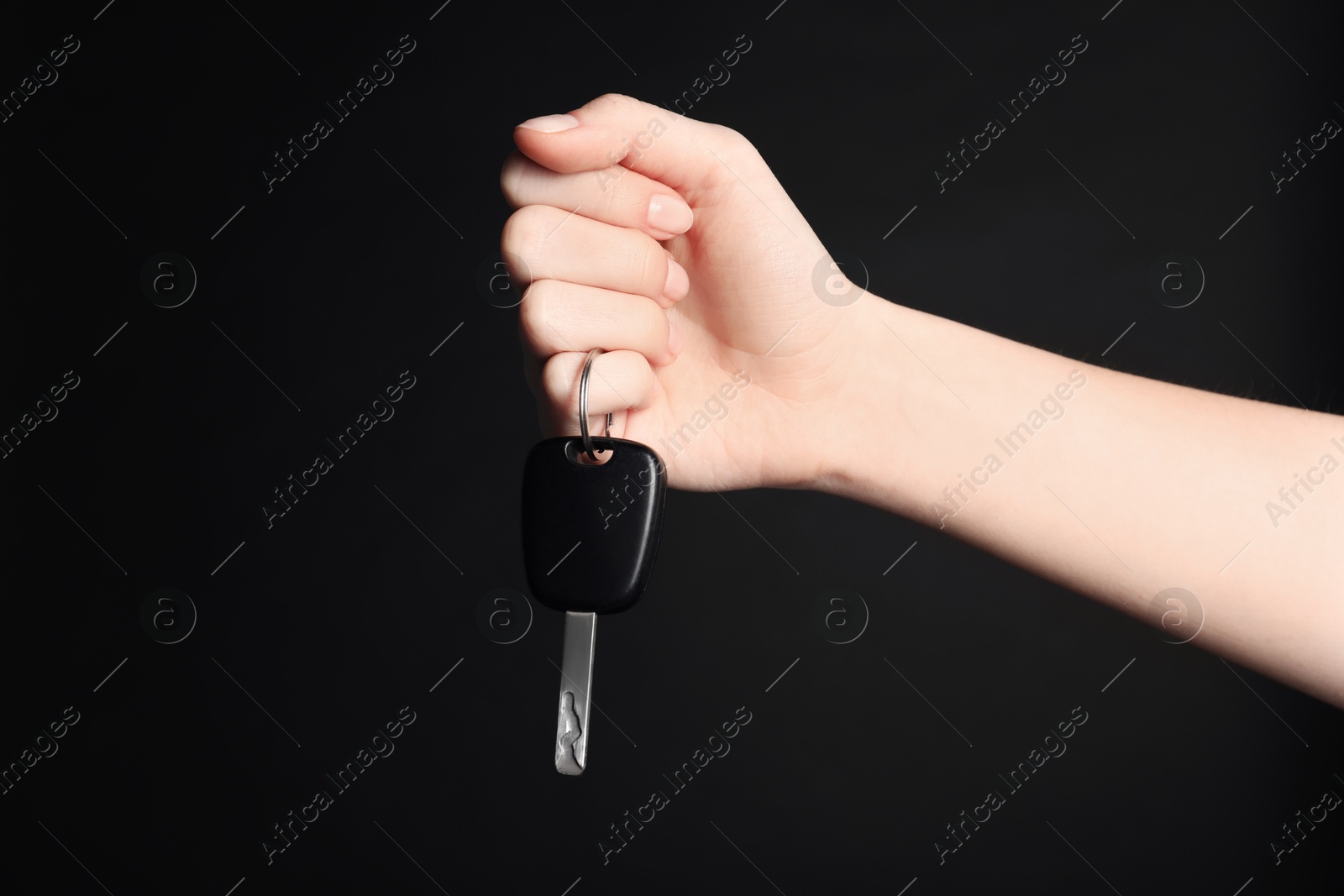 Photo of Woman with car key on black background, closeup