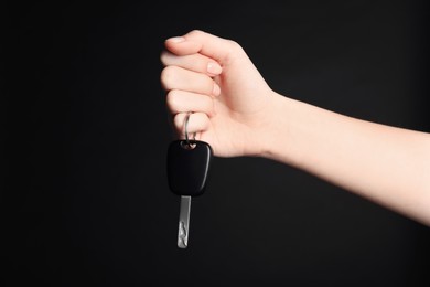 Photo of Woman with car key on black background, closeup