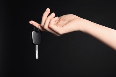 Photo of Woman with car key on black background, closeup