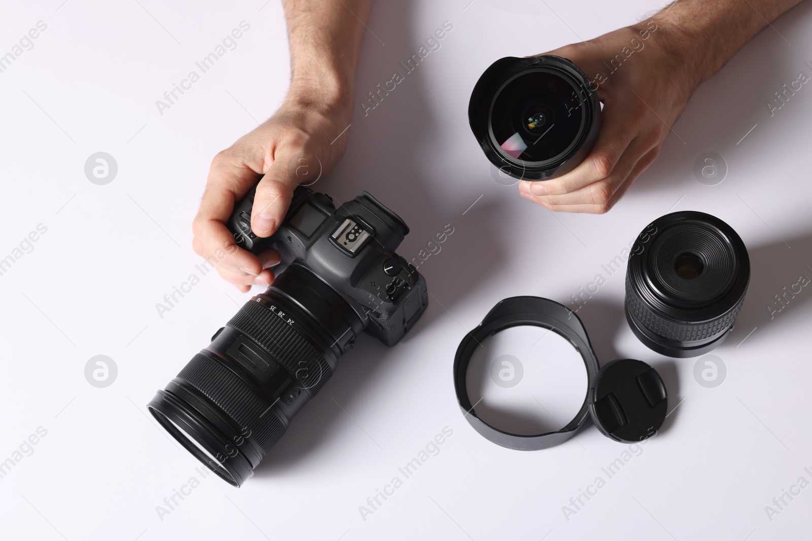 Photo of Photographer with professional camera and equipment on light background, top view