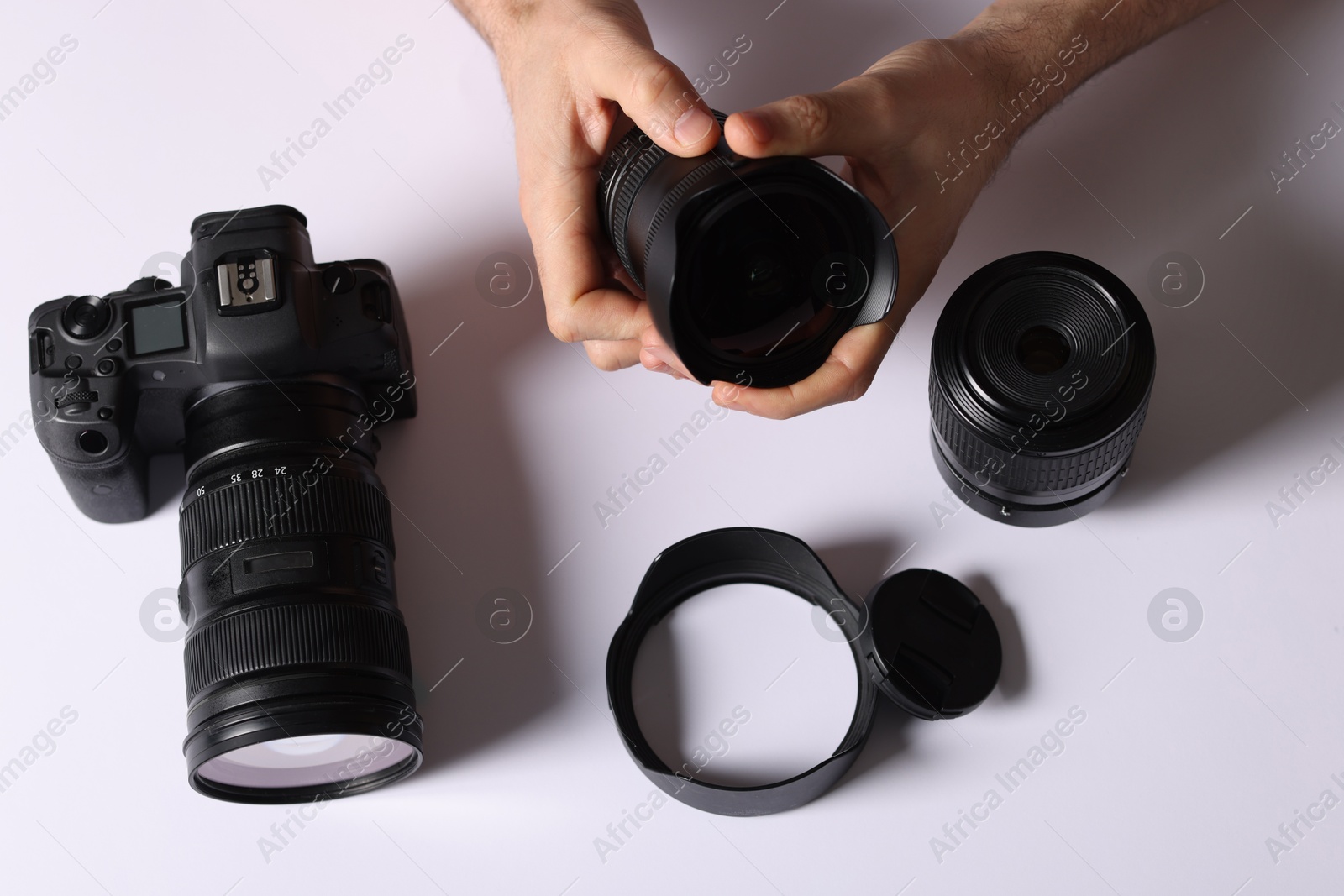 Photo of Photographer with professional camera and equipment on light background, top view