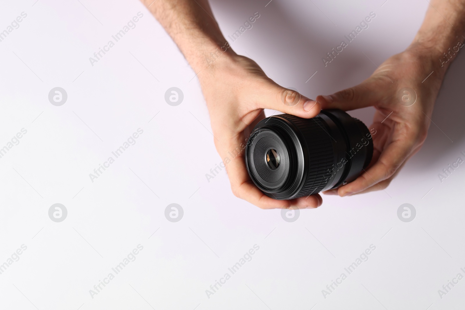 Photo of Photographer with camera lens on light background, top view. Space for text