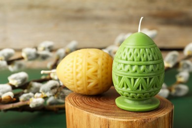 Photo of Colorful egg-shaped candles on table, closeup. Easter decor