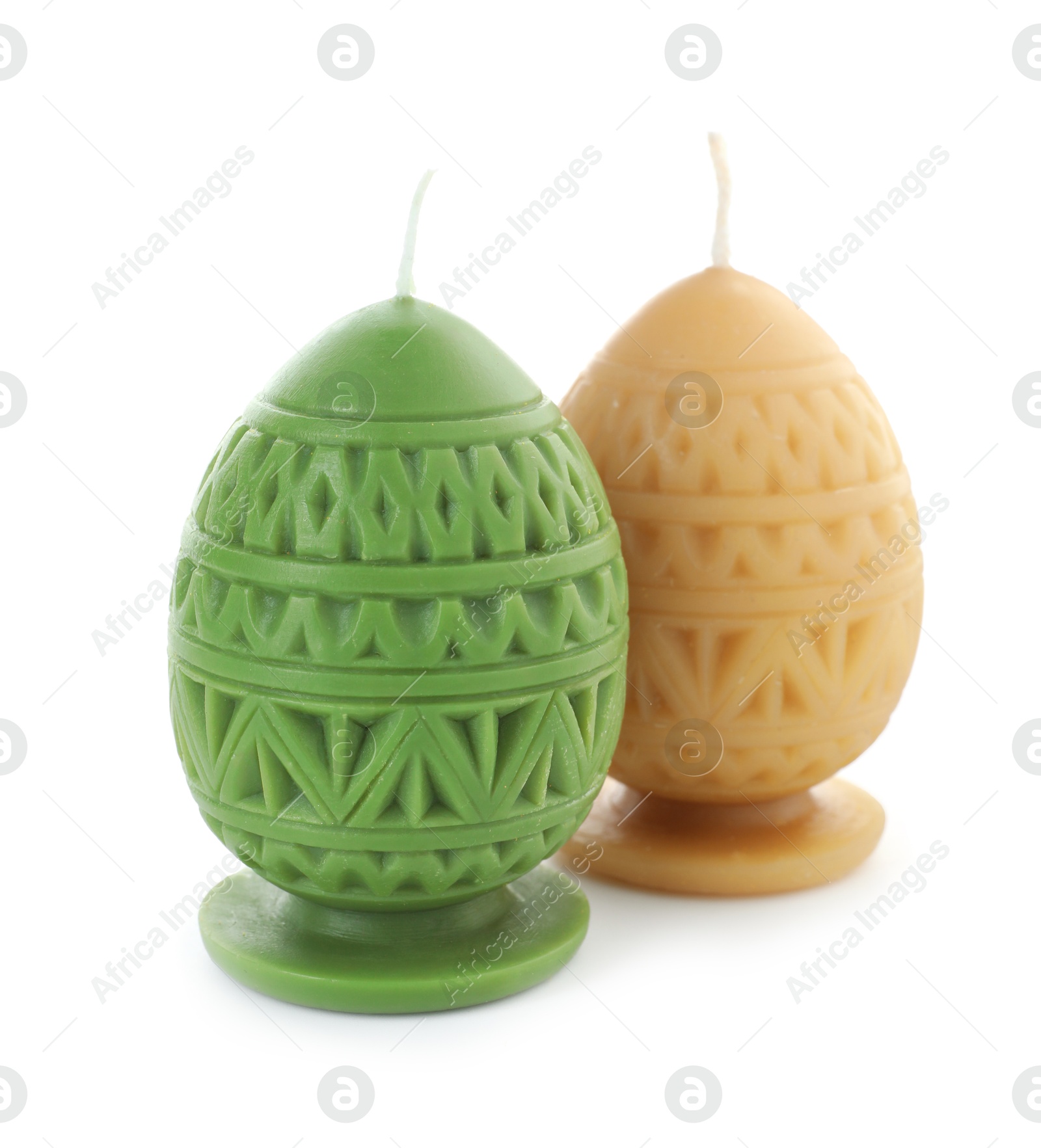 Photo of Colorful egg-shaped candles isolated on white. Easter decor