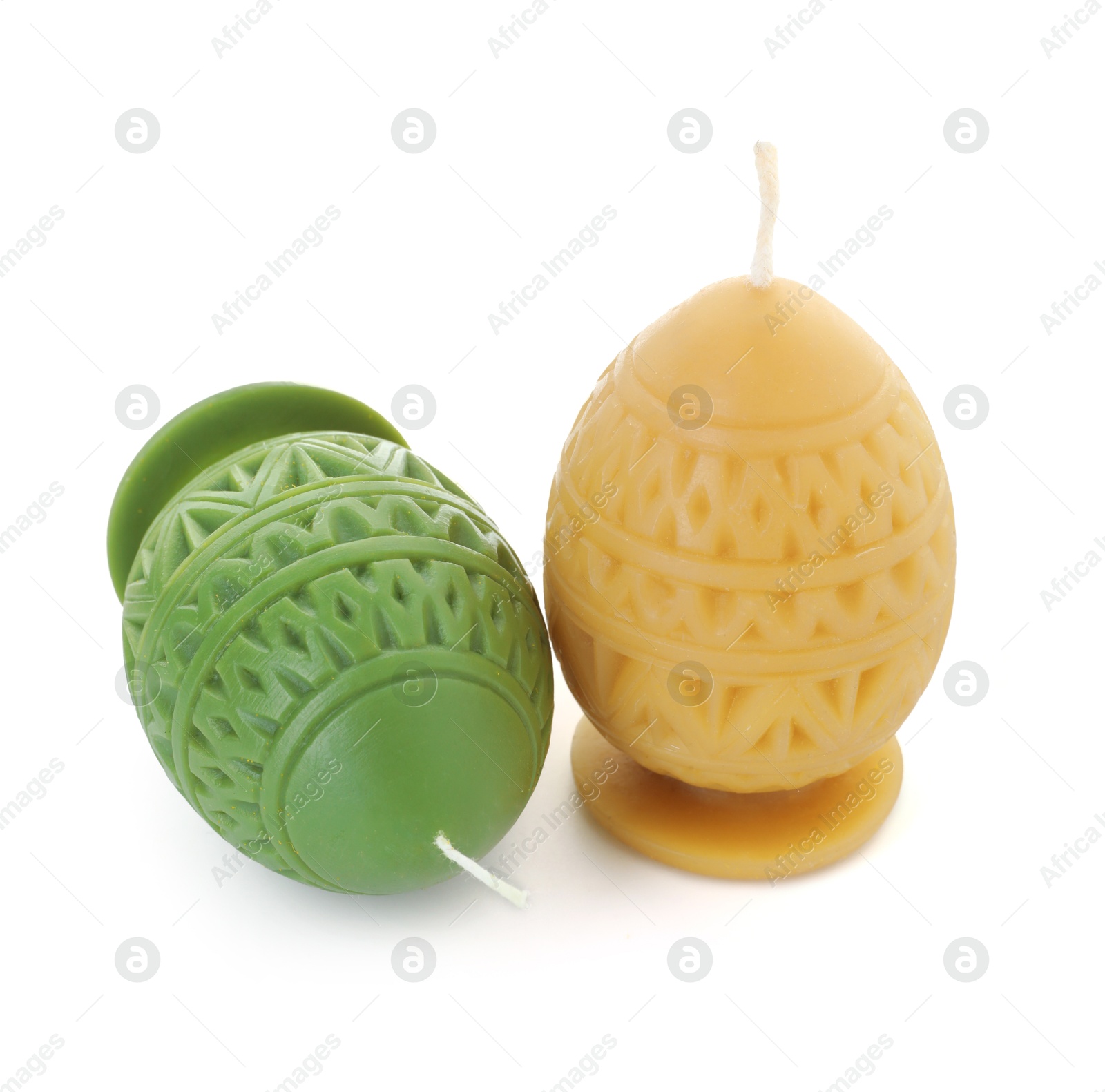 Photo of Colorful egg-shaped candles isolated on white. Easter decor