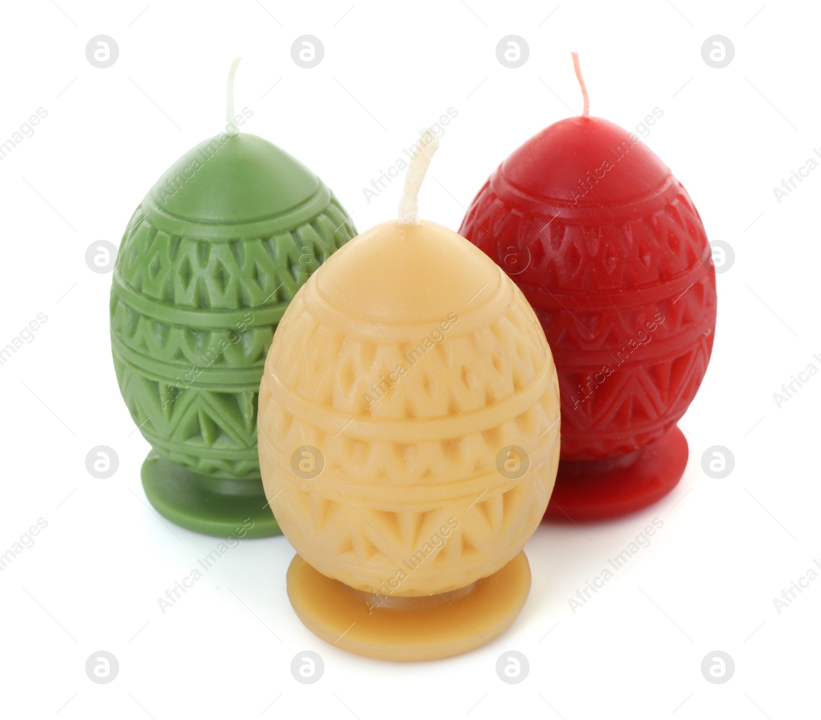 Photo of Colorful egg-shaped candles isolated on white. Easter decor